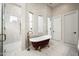 Stunning bathroom with freestanding tub, marble-tiled walk-in shower, and white and gold finishes at 39847 N 105Th Pl, Scottsdale, AZ 85262
