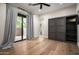 Versatile bedroom space featuring a Murphy bed, sliding doors, hardwood floors, and outdoor access at 39847 N 105Th Pl, Scottsdale, AZ 85262