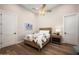 Well-lit bedroom with hardwood floors, ceiling fan and a cozy bed at 39847 N 105Th Pl, Scottsdale, AZ 85262