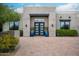 Elegant front entrance with a striking modern door, manicured greenery, and a brick driveway at 39847 N 105Th Pl, Scottsdale, AZ 85262