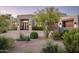 A beautiful front exterior showcasing the property's desert landscaping, brick paved driveway, and architectural features at 39847 N 105Th Pl, Scottsdale, AZ 85262