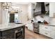 Modern kitchen island with a stainless steel range and custom hood at 39847 N 105Th Pl, Scottsdale, AZ 85262