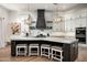 Modern kitchen with a large island, granite countertops, stainless steel appliances and custom hood at 39847 N 105Th Pl, Scottsdale, AZ 85262