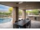 Outdoor dining area with a grill, table, and pool view for entertaining at 39847 N 105Th Pl, Scottsdale, AZ 85262