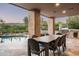 A covered outdoor dining area featuring a built-in grill, mountain views, and a sparkling pool at 39847 N 105Th Pl, Scottsdale, AZ 85262