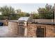 Outdoor kitchen features a built-in grill, stainless steel appliances, and stone accents at 39847 N 105Th Pl, Scottsdale, AZ 85262
