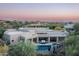 A beautiful rear exterior showcasing the property's pool, patio seating, and desert landscaping with a picturesque mountain backdrop at 39847 N 105Th Pl, Scottsdale, AZ 85262