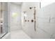 Luxurious walk-in shower featuring dual shower heads, a built-in bench, and white marble style tile at 39847 N 105Th Pl, Scottsdale, AZ 85262