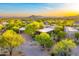 This aerial view highlights the home's circular driveway, mature trees, desert landscape, and stunning scenery at 41590 N 108Th St, Scottsdale, AZ 85262