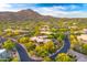 This aerial view highlights desert landscaping, neighborhood homes and beautiful mountain views at 41590 N 108Th St, Scottsdale, AZ 85262