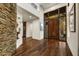 Home foyer featuring a stone accent wall, hardwood floors, and statement front door at 41590 N 108Th St, Scottsdale, AZ 85262