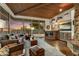 Spacious living room featuring a stone fireplace, wooden ceilings, and floor-to-ceiling windows at 41590 N 108Th St, Scottsdale, AZ 85262