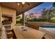 Covered outdoor dining area with a grill, pool view, and desert scenery at 41590 N 108Th St, Scottsdale, AZ 85262