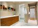 Modern bathroom with wooden drawers, a glass shower, and white tile flooring at 42155 N 97Th Way, Scottsdale, AZ 85262