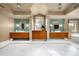 Luxurious primary bathroom featuring dual vanities, a central dressing table, and bright lighting at 42155 N 97Th Way, Scottsdale, AZ 85262