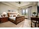 Comfortable bedroom featuring a wooden sleigh bed, soft lighting, and window with nature view at 42155 N 97Th Way, Scottsdale, AZ 85262