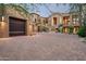 Elegant home showcasing a lush desert landscape, with a sprawling driveway leading to a spacious three-car garage at 42155 N 97Th Way, Scottsdale, AZ 85262