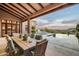 Inviting covered patio featuring an outdoor dining area, pool, and desert view at 42155 N 97Th Way, Scottsdale, AZ 85262