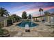 An outdoor swimming pool with travertine tiling, landscaping, diving board, outdoor furniture, and BBQ grill at 5225 E Hearn Rd, Scottsdale, AZ 85254
