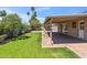 Lush backyard with well-maintained lawn, mature trees, and a covered patio for relaxation and entertainment at 5319 E Gelding Dr, Scottsdale, AZ 85254