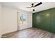 Bedroom featuring green accent wall, window with a view, and wood-look floors at 5319 E Gelding Dr, Scottsdale, AZ 85254