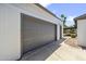 Detached two-car garage with modern gray door and well-maintained exterior, and adjacent carport at 5319 E Gelding Dr, Scottsdale, AZ 85254