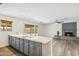 Spacious kitchen with an island, seamlessly connected to a living area featuring a cozy brick fireplace at 5319 E Gelding Dr, Scottsdale, AZ 85254