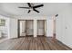 Bright bedroom featuring wood-look floors, ceiling fan, and closet storage at 5319 E Gelding Dr, Scottsdale, AZ 85254