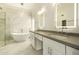 Elegant bathroom features a soaking tub, glass enclosed shower, dual vanity sinks, and modern lighting at 5402 E Michelle Dr, Scottsdale, AZ 85254