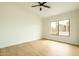 Bedroom features light wood floors, ceiling fan, and backyard views at 5402 E Michelle Dr, Scottsdale, AZ 85254