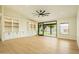 Well-lit living room featuring wood floors, modern ceiling fan, built-in shelving, and backyard access at 5402 E Michelle Dr, Scottsdale, AZ 85254