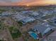 Stunning aerial view of homes featuring backyard pools and landscaping under a sunset at 5901 E Sierra Morena St, Mesa, AZ 85215