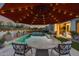 Beautifully designed backyard featuring a pool, spa, dining area under an umbrella, and meticulously landscaped grounds at 5901 E Sierra Morena St, Mesa, AZ 85215