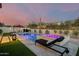 Gorgeous backyard featuring a sparkling pool, spa, outdoor lounge area, and manicured landscaping for ultimate relaxation at 5901 E Sierra Morena St, Mesa, AZ 85215
