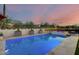 Serene backyard oasis with a pool, spa, stylish landscaping, and ambient lighting for evening enjoyment at 5901 E Sierra Morena St, Mesa, AZ 85215