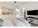 Bright primary bedroom with a walk-in closet, art on the wall, and a large TV mounted on the wall at 5901 E Sierra Morena St, Mesa, AZ 85215