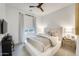Bright bedroom with a ceiling fan, window with blinds, and a king bed with upholstered headboard and side tables at 5901 E Sierra Morena St, Mesa, AZ 85215