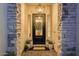 Inviting front entrance featuring a modern, black door with glass, decorative wreath, and stone columns at 5901 E Sierra Morena St, Mesa, AZ 85215