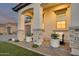 Close-up of a front porch with stone pillars, potted plants, and a seating area at 5901 E Sierra Morena St, Mesa, AZ 85215