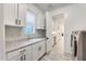 Bright laundry room with a window, granite countertops, white cabinets, and stainless steel appliances at 5901 E Sierra Morena St, Mesa, AZ 85215