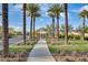 Landscaped walkway features lush green grass, manicured shrubs, and tall palms at 5901 E Sierra Morena St, Mesa, AZ 85215
