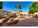 Resort style backyard with outdoor kitchen, seating, water feature and fire pit perfect for entertaining guests at 7002 E Exmoor Dr, Mesa, AZ 85208