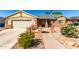 Charming home with a two-car garage, beautiful stone accents, and meticulous desert landscaping at 7002 E Exmoor Dr, Mesa, AZ 85208