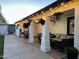 The covered patio features a ceiling fan, patio furniture and hanging plants at 7943 W Mariposa Dr, Phoenix, AZ 85033