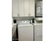 This laundry room features a washing machine, dryer and upper cabinets at 7943 W Mariposa Dr, Phoenix, AZ 85033