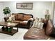 Cozy living room features comfortable leather seating, a decorative coffee table, and a warm, inviting atmosphere at 7943 W Mariposa Dr, Phoenix, AZ 85033