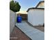 Exterior side yard with a concrete walkway, privacy fence, and convenient alley access and trash receptacle area at 7943 W Mariposa Dr, Phoenix, AZ 85033