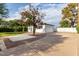 Exterior view of the charming home showcasing the landscape, expansive driveway, and two-car garage at 819 N Robson --, Mesa, AZ 85201