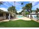 Backyard pool and patio area with lush turf, palm trees, and an outdoor kitchen at 8306 E Via De Dorado --, Scottsdale, AZ 85258