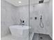 Modern bathroom featuring soaking tub, glass enclosed shower and marble style tile at 8316 E Glenrosa Ave, Scottsdale, AZ 85251
